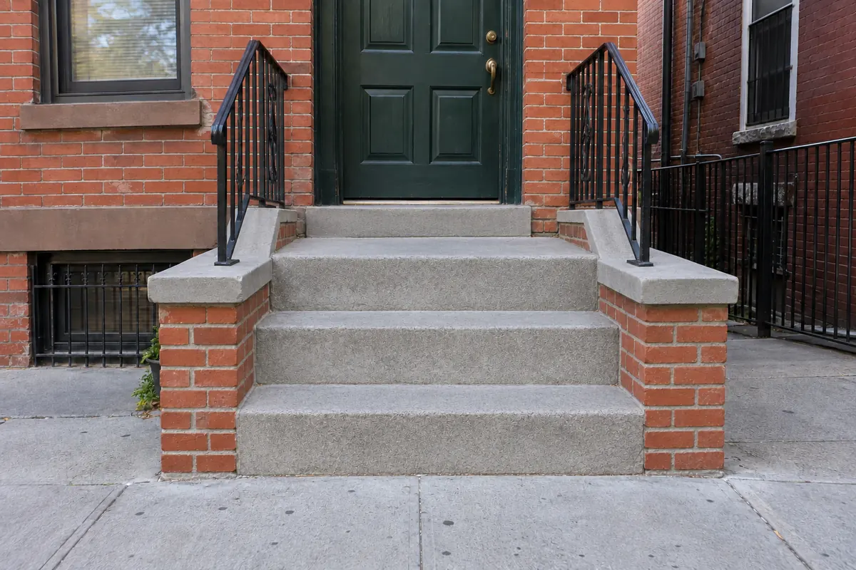 Smooth restored concrete entrance steps after stoop and step repair in NYC