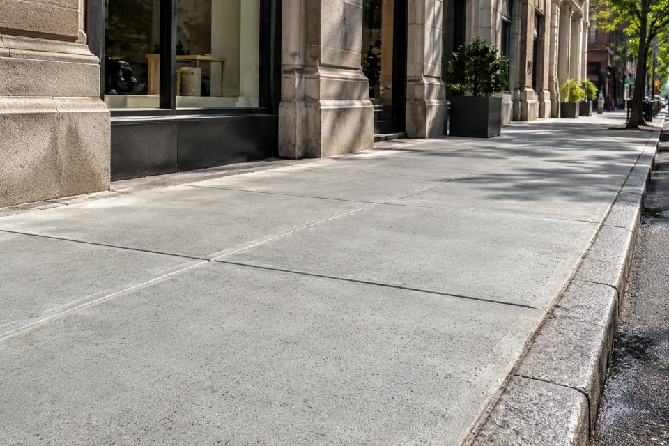 Repaired concrete sidewalk serving residential and commercial NYC properties