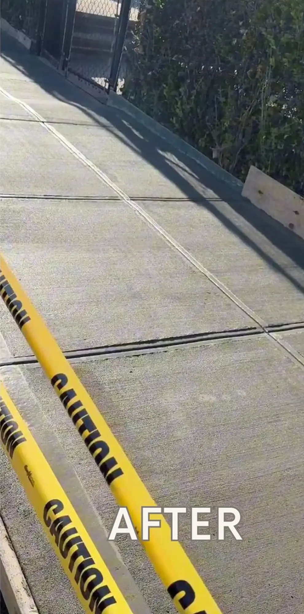 Newly finished concrete pavement with control joints and construction caution tape along the work area.