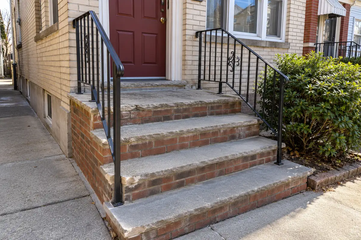 Worn and deteriorated concrete stoop before repair at an NYC residential property