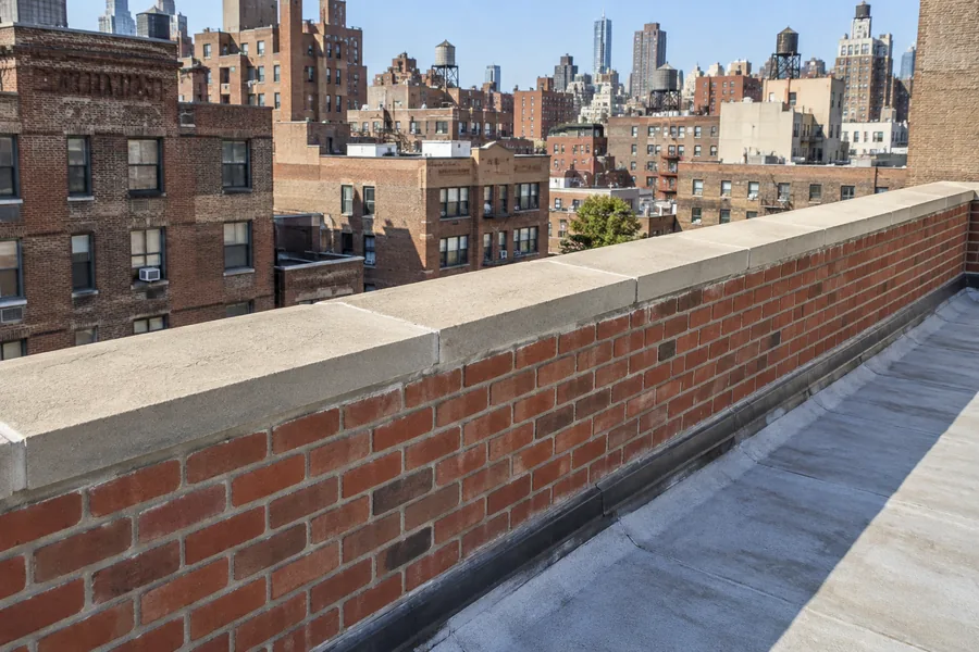 Brick parapet wall repointing and mortar repair on an NYC rooftop