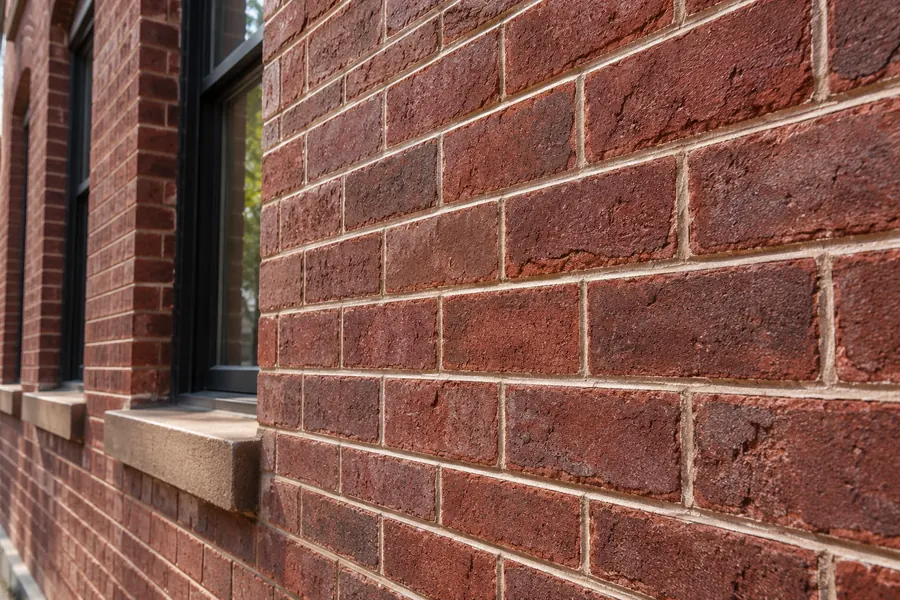 Tuckpointing work restoring worn mortar joints on an NYC brick facade